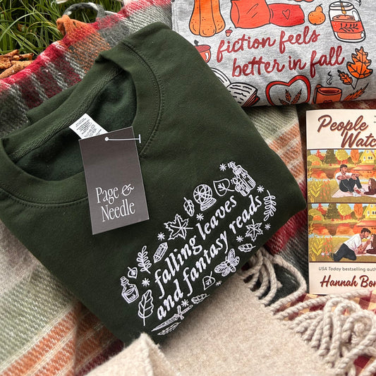 Plaid blanket with books, a t-shirt, and a coffee cup on grass