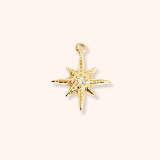 Gold star-shaped pendant with a central gemstone on a white background