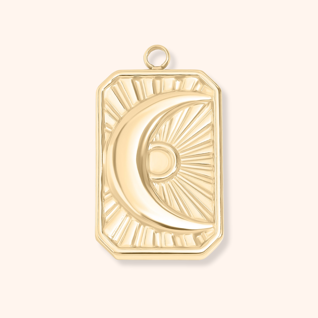 Gold pendant with a moon design on a white background