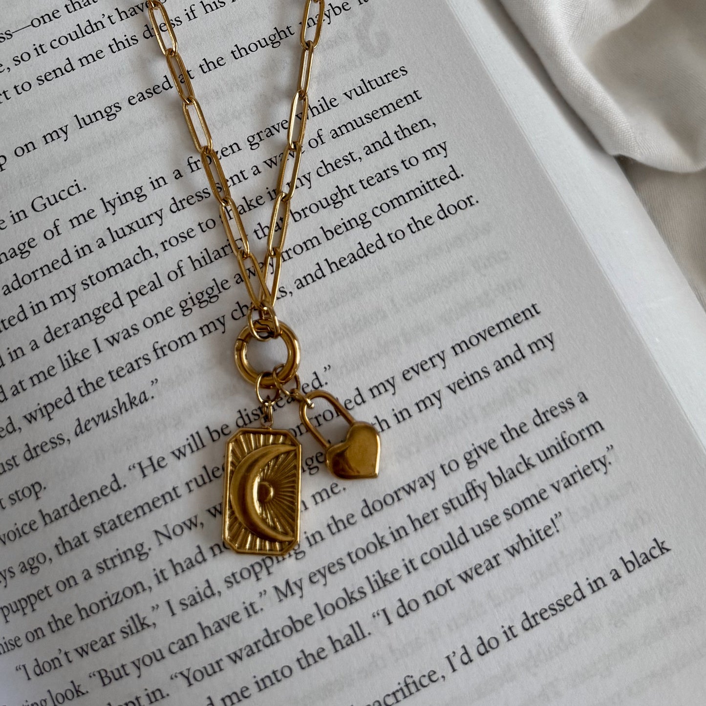 Gold necklace with a pendant on an open book