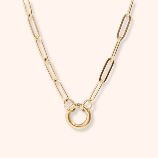 Gold chain necklace with a unique ring design on a light background