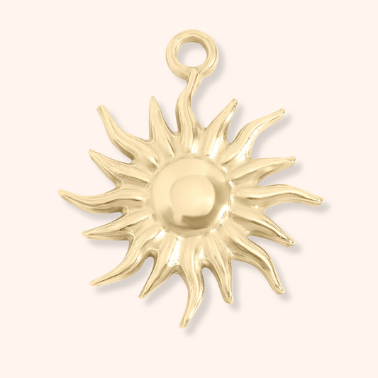 Gold sun-shaped pendant on a white background