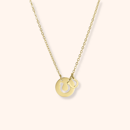 Gold necklace with two interlocking rings on a white background