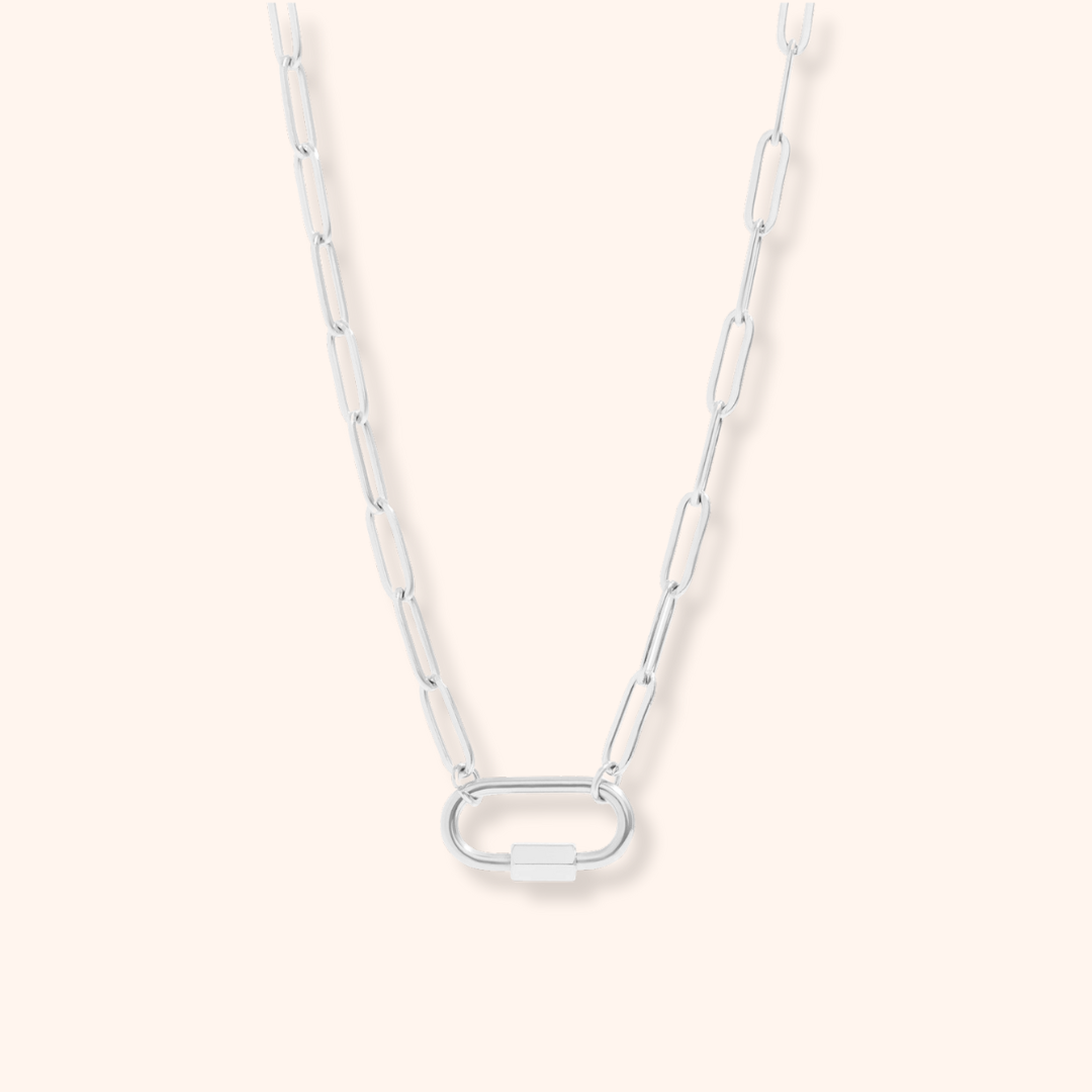 Silver chain necklace on a light pink background