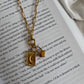 Gold necklace with a pendant on an open book