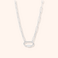 Silver chain necklace on a light pink background