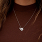 Silver necklace with a pendant on a brown shirt